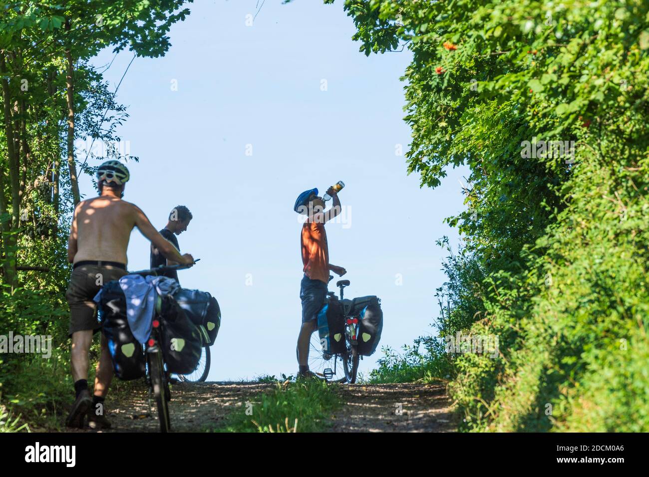 : cyclists pushing bicycles, drinking water in , Liberecky,  Liberec Region, Reichenberger Region , Czech Stock Photo