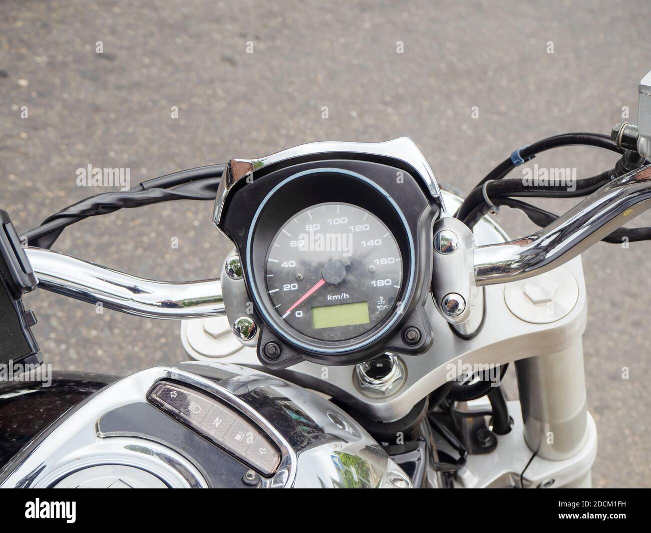 Fragment of a motorcycle steering wheel with a round speedometer. Close-up photo Stock Photo