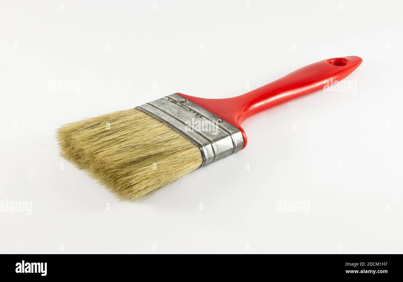 Old and used red paint brush isolated on white background. Stock Photo