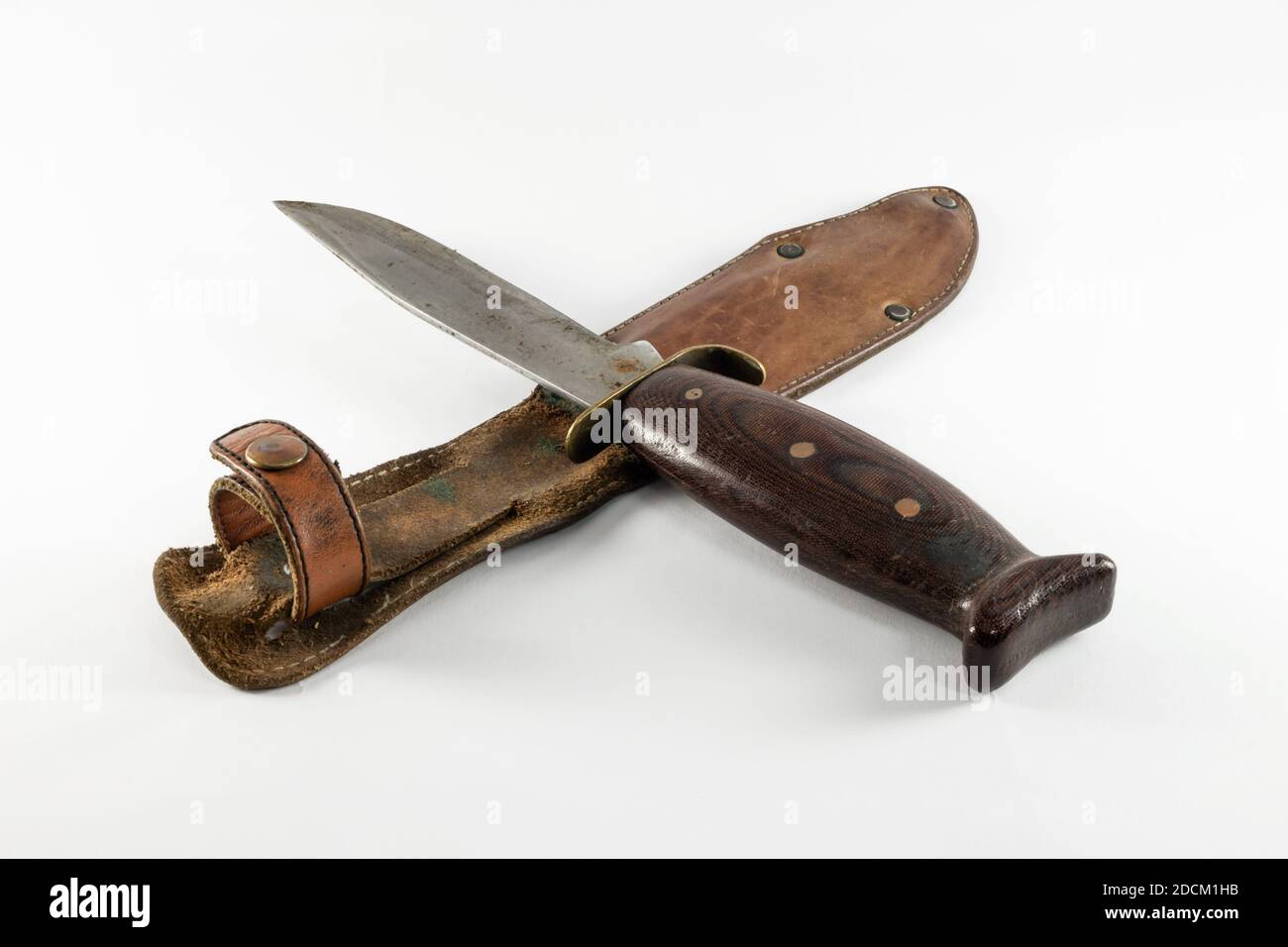 Old rusty vintage hunting bushcraft knife with leather sheath. Isolated on white background, copy space. Stock Photo