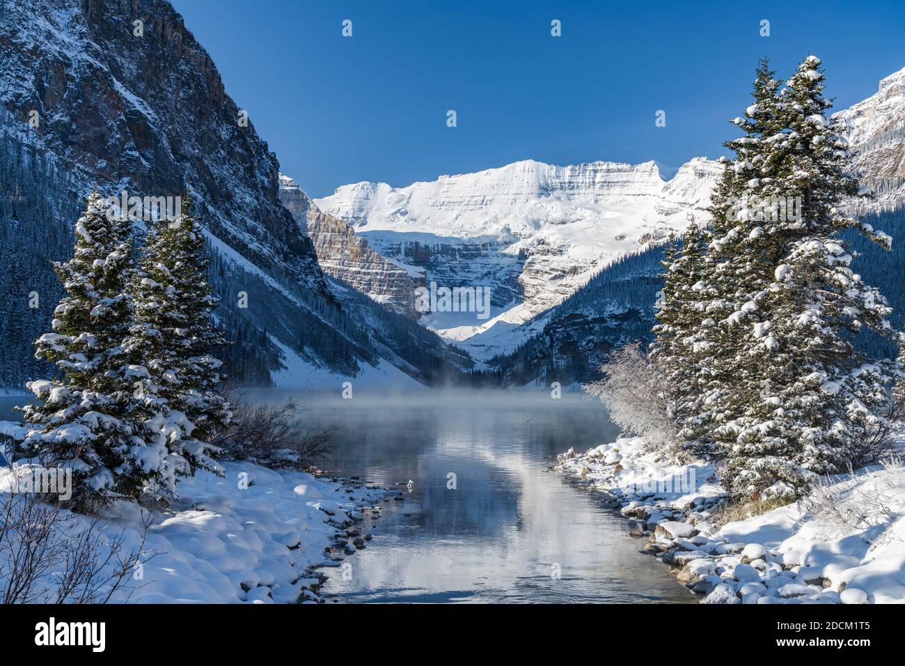Lake Louise in early winter sunny day morning. Mist floating on ...