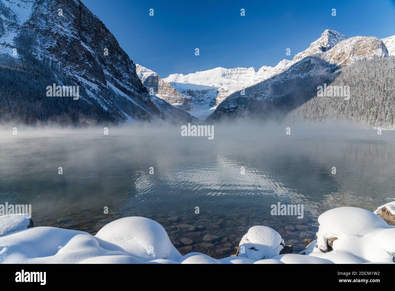 Lake Louise in early winter sunny day morning. Mist floating on ...
