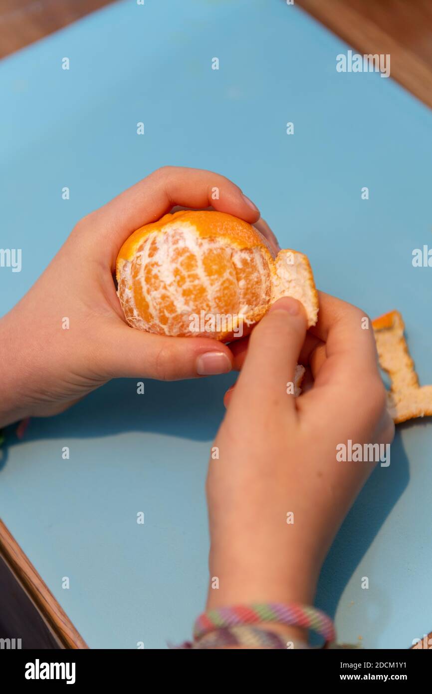 Girl peeling a clementine Stock Photo Alamy