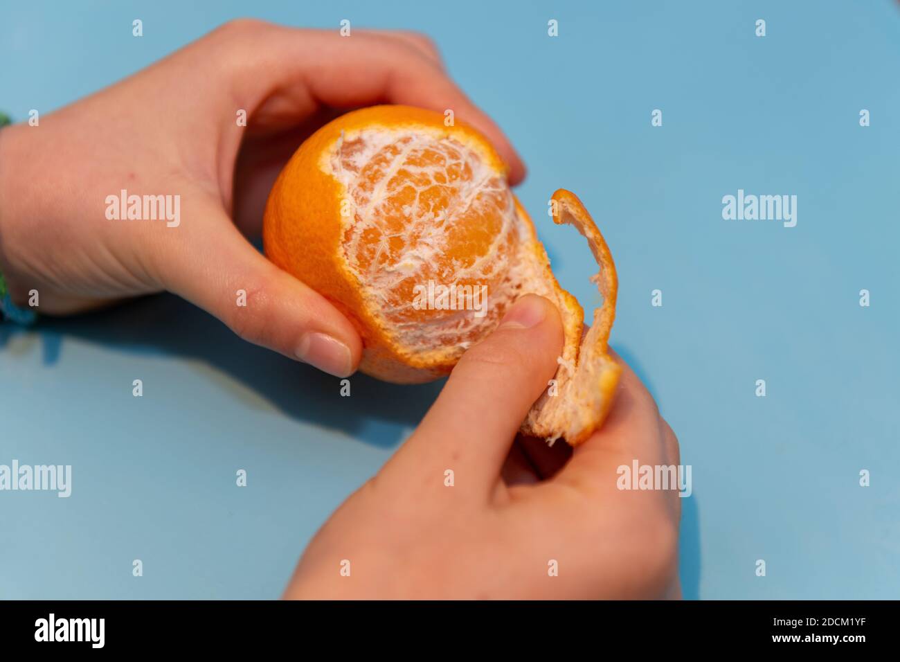Girl peeling a clementine Stock Photo Alamy