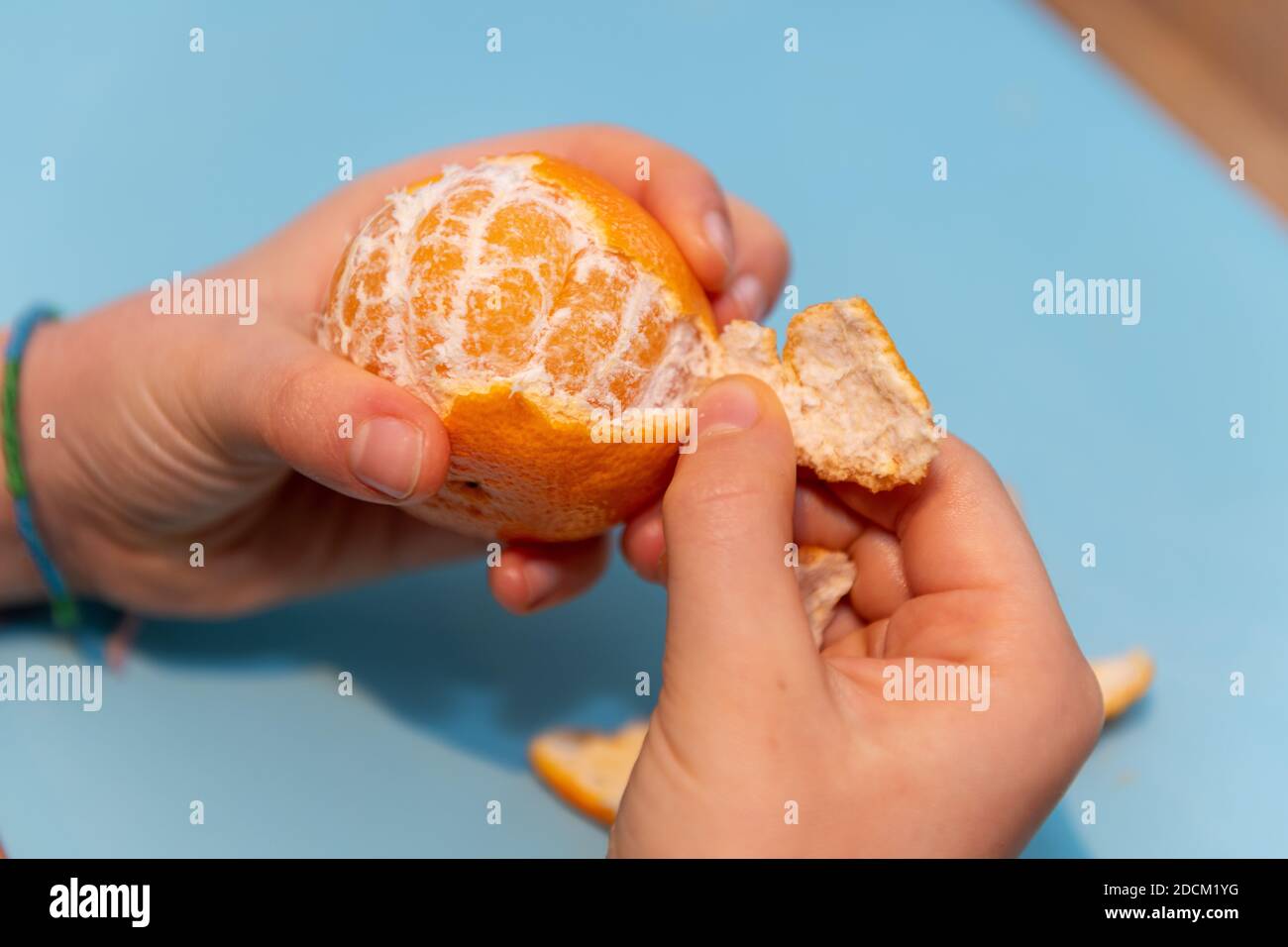 Girl peeling a clementine Stock Photo Alamy