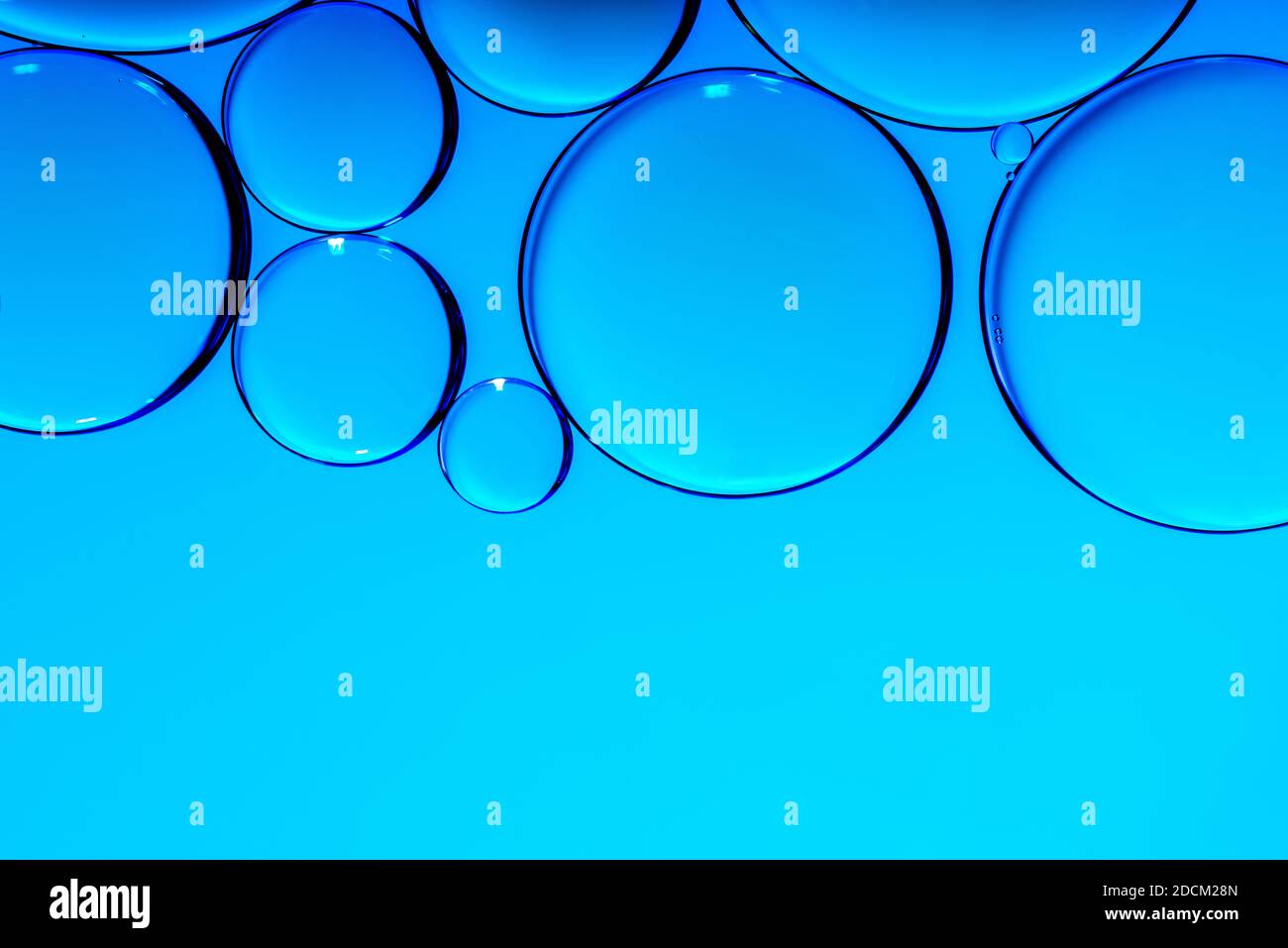 Blue oil drops in water. Bubbles of different sizes on blue abstract background Stock Photo