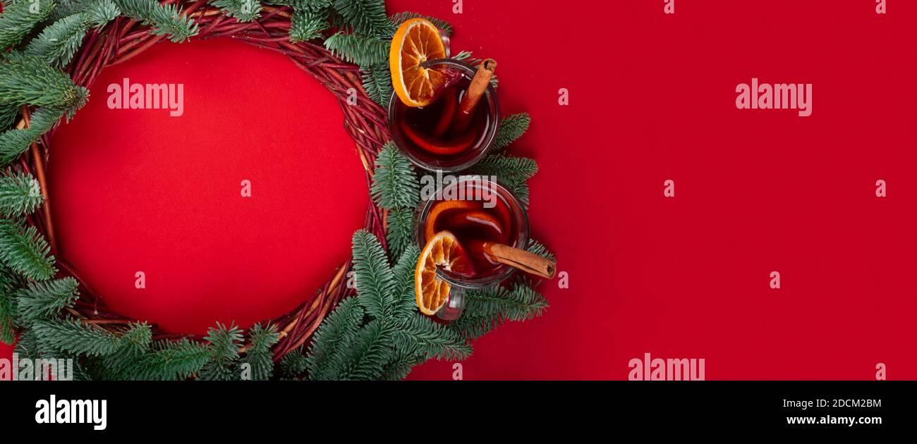 Christmas decorative wreath with noble fir tree twigs and mulled wine on red paper background with copy space for text Stock Photo