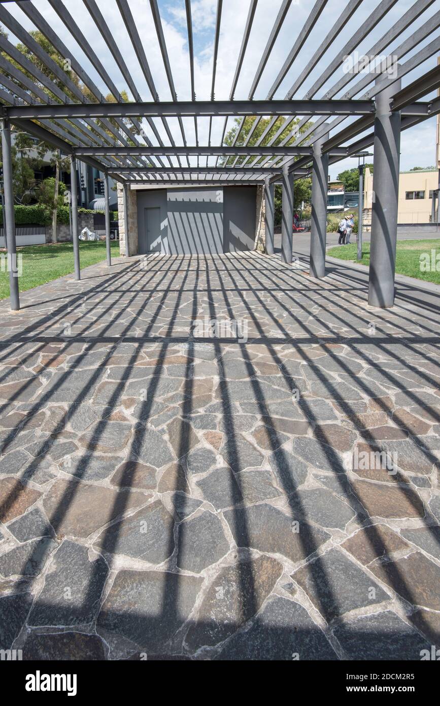 An artistic steel and timber structure frames a path that leads down to a park at Blackwattle Bay in Sydney Harbour, New South Wales, Australia Stock Photo