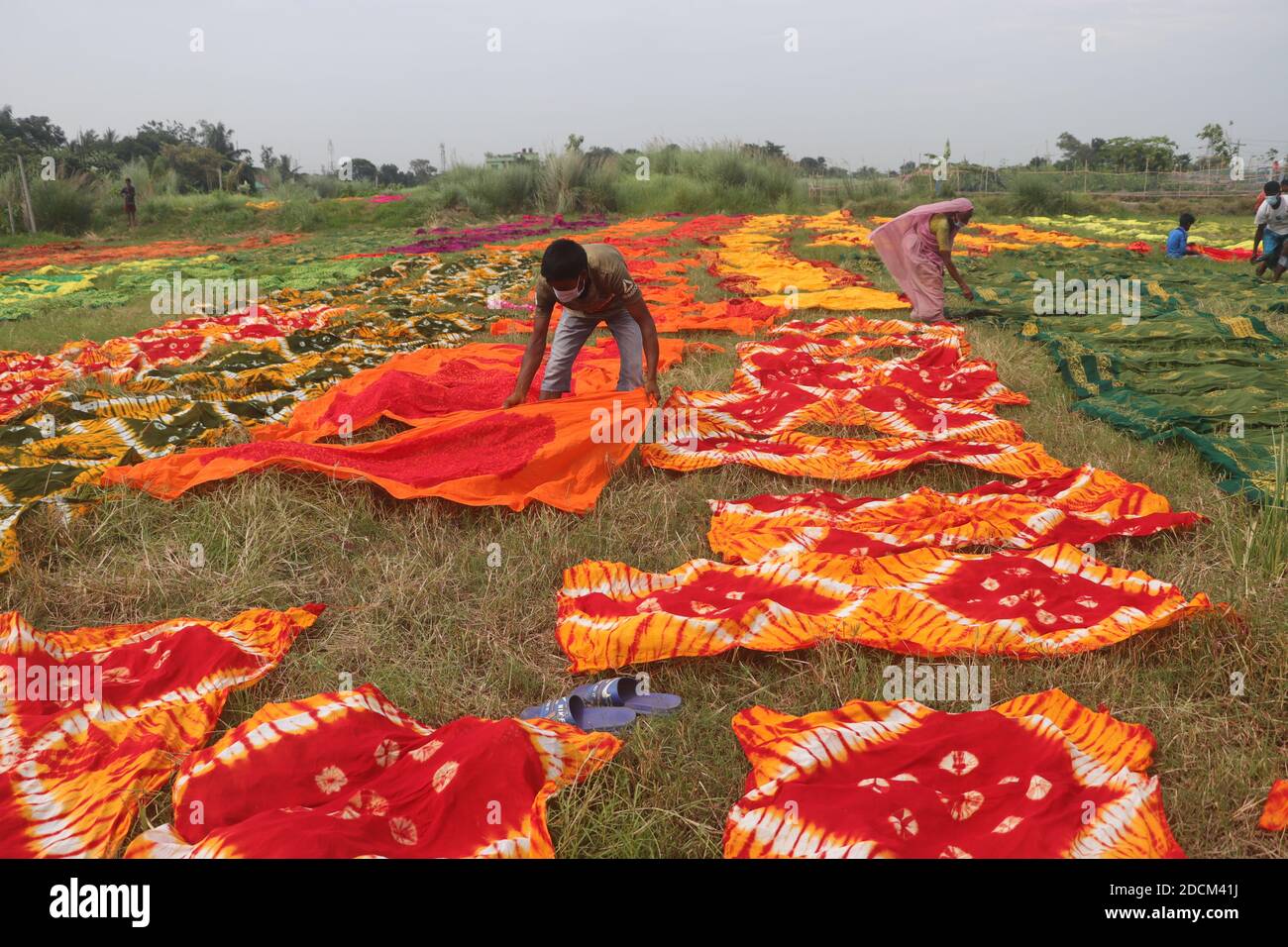 Bangladeshi workers collect fabric after dry them under the sun at a dyeing factory in Narayanganj, near Dhaka, Bangladesh, Nazmul Islam/alamay.com Stock Photo