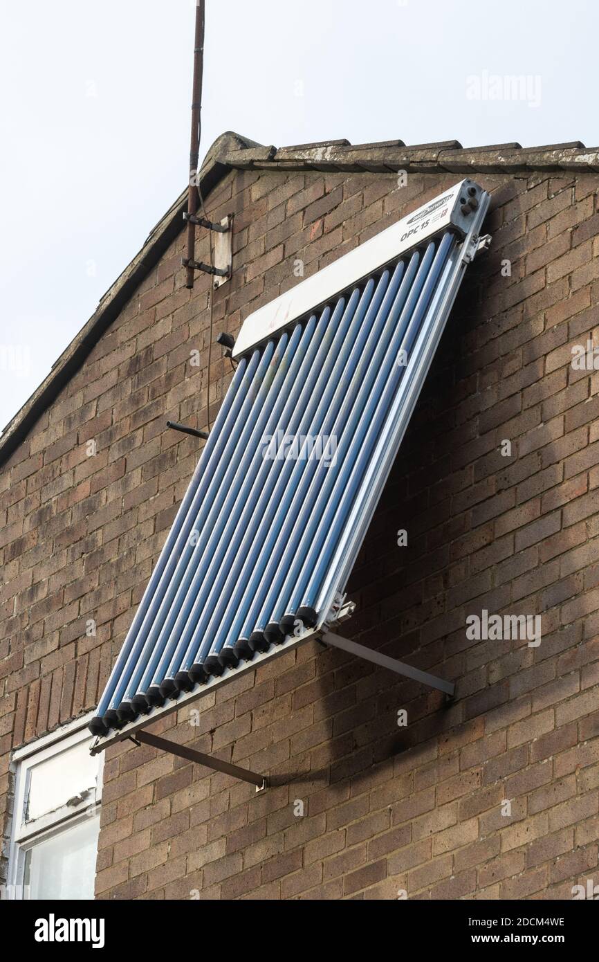 A solar thermal panel, evacuated tube, OPC 15, mounted on the wall of a house, UK. Renewable green sustainable energy for the home. Stock Photo