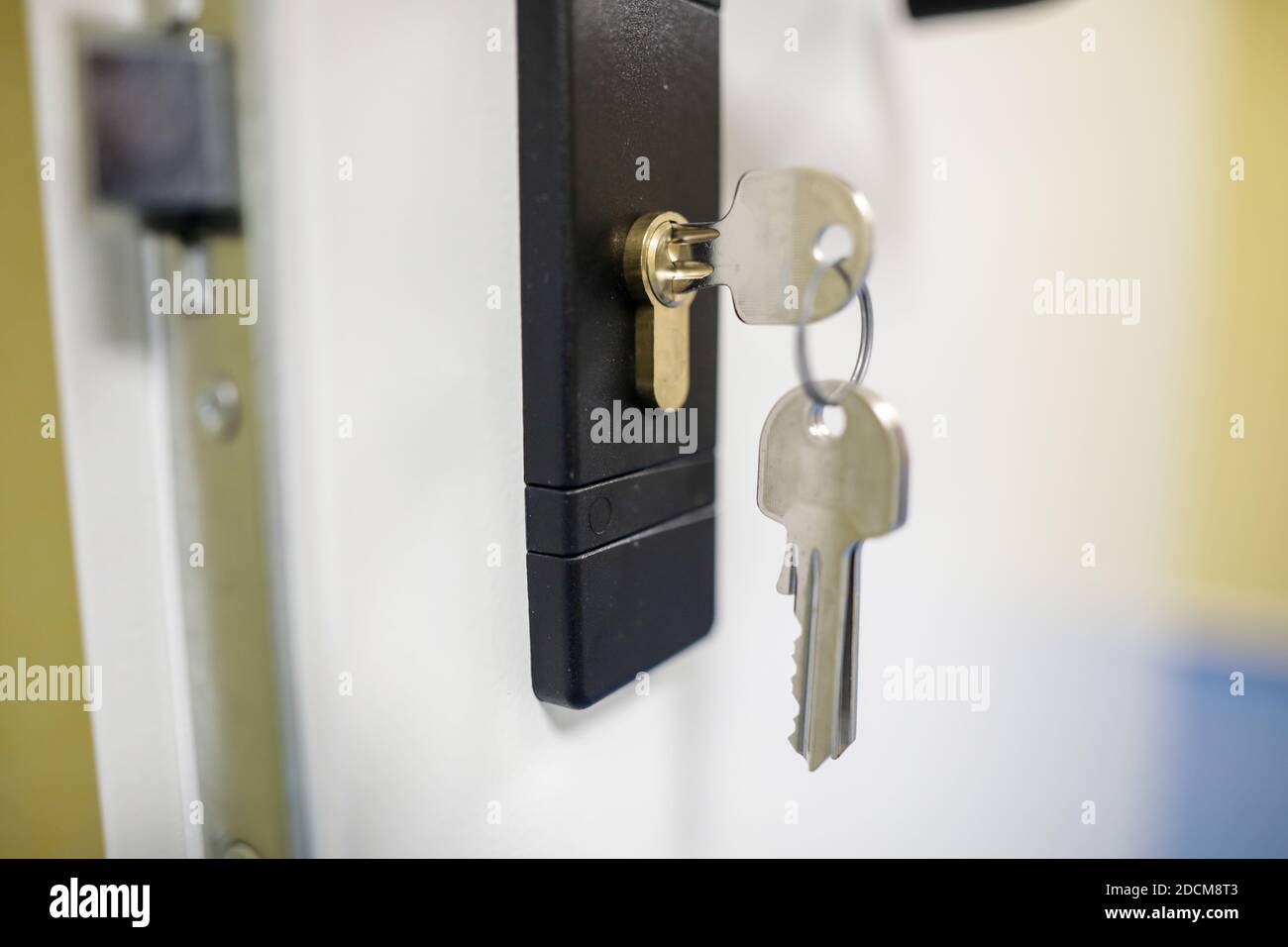 Shallow depth of field (selective focus) image with metal keys into a door lock. Stock Photo