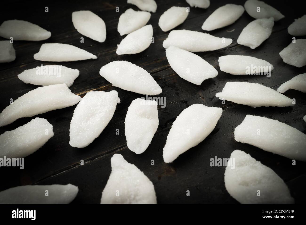 Frozen slices of squid on the black background. Hipster style pattern Stock Photo
