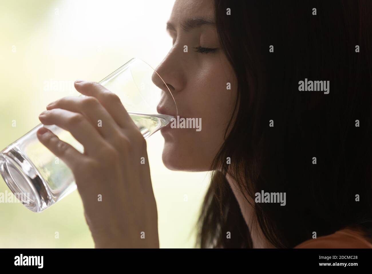 Millennial woman drinking mineral water, feeling thirsty Stock Photo