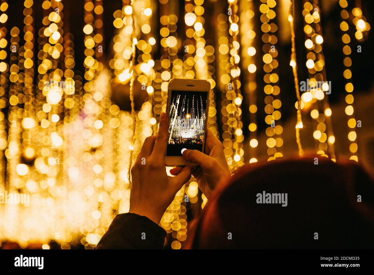 The girl takes pictures of Christmas or New Year's lights on the phone