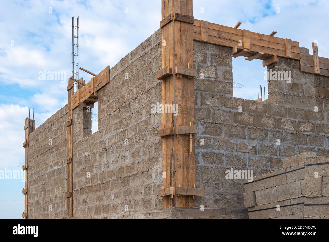 Construction stages. Cinder block house with protruding fittings, ground floor. Stock Photo