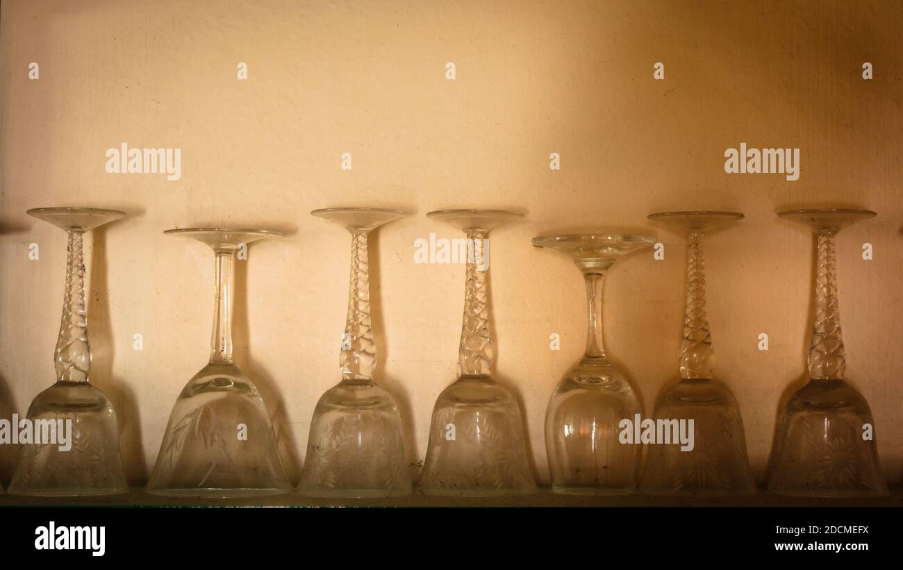 Old wine glasses on a wall display in an old house. Stock Photo