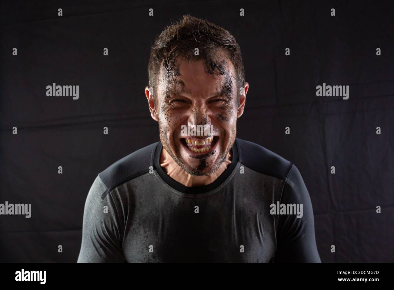 Sporty man screams from physical exertion, during a sports competition on a black background Stock Photo