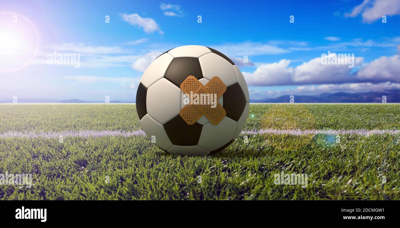 Football injury, first aid. Soccer ball with a band aid on green grass