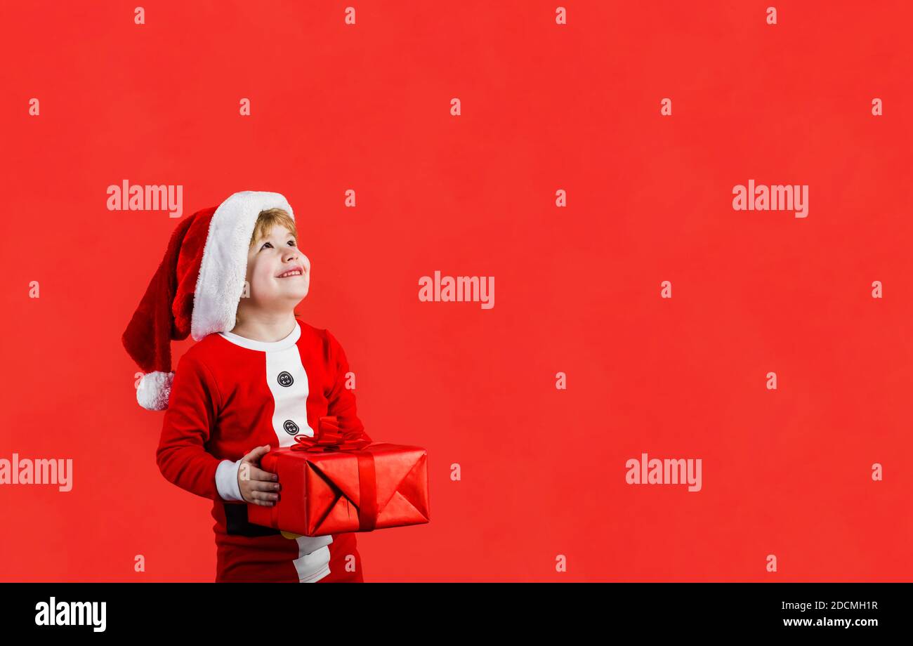 Christmas boy. Little kid celebrating Christmas. Little boy with Christmas present. New year kid. Wintertime. Santa kid holds present box Stock Photo