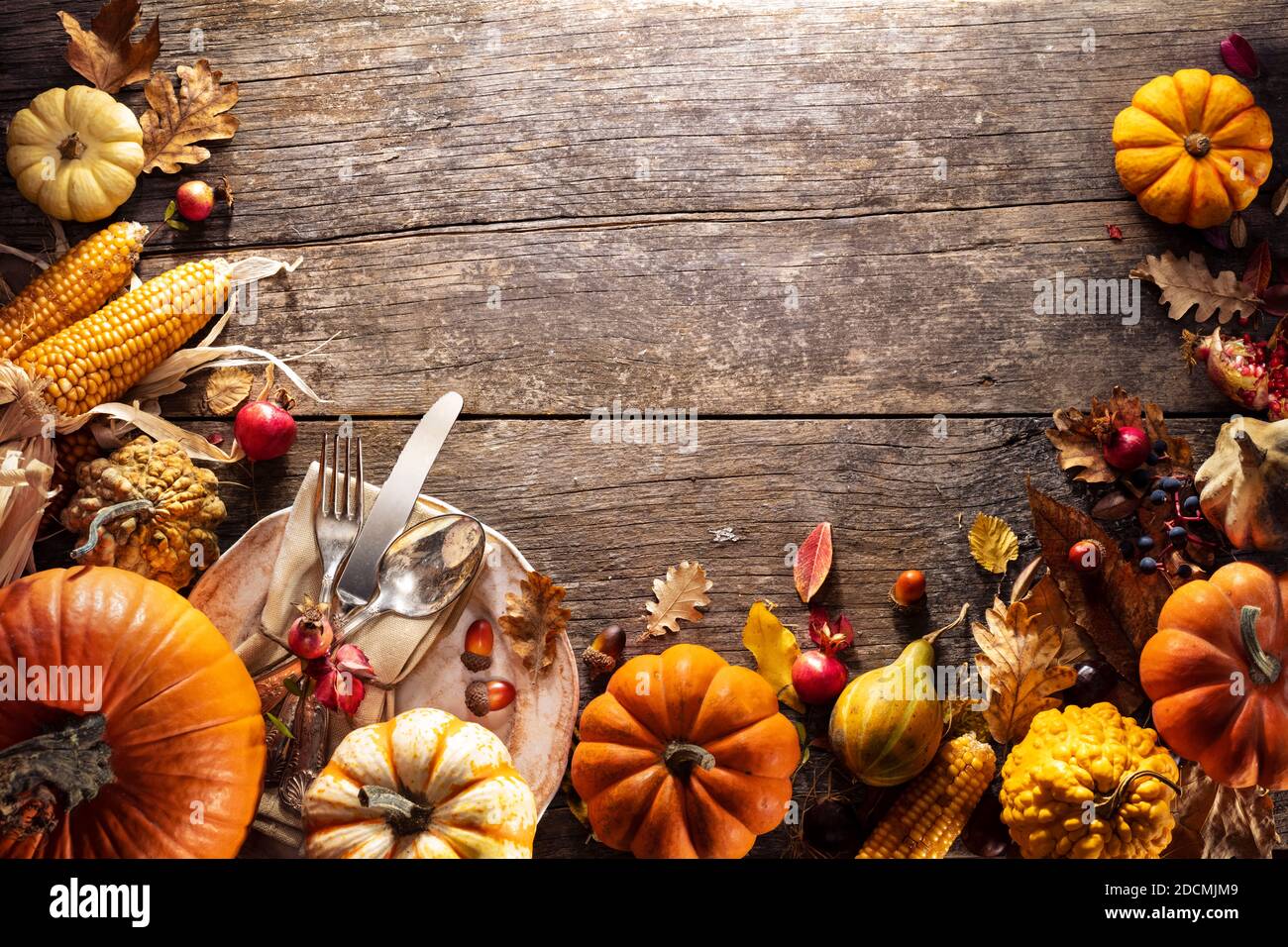 Thanksgiving Board - Table Setting With Silverware And Pumpkins On Aged Wooden Plank Stock Photo