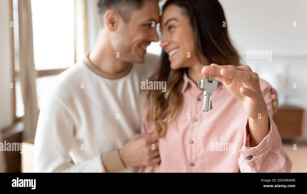 Couple hugging holding keys to the new house, closeup Stock Photo - Alamy