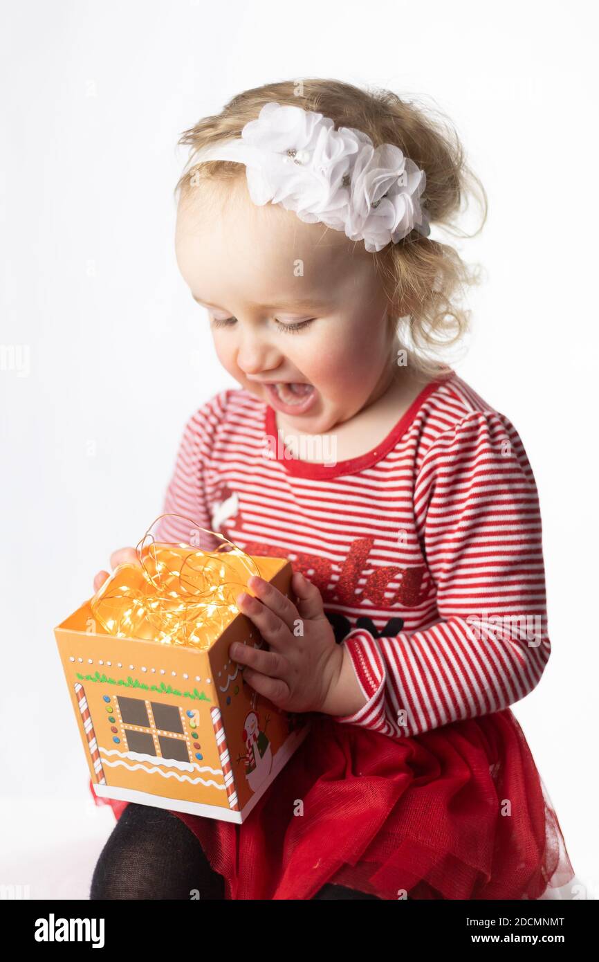 Baby with Christmas JOY and cheer and Holiday excitement for baby girl. Toddler female with Christmas theme. 2 year old Canadian girl with Christmas Stock Photo