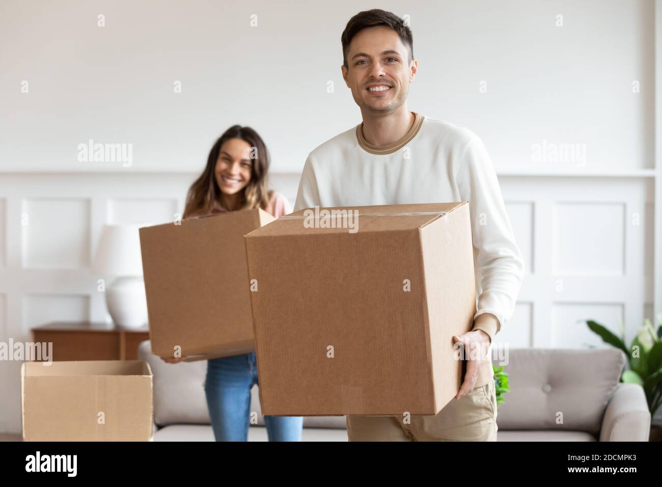 Couple holding cardboard boxes relocating to new home Stock Photo