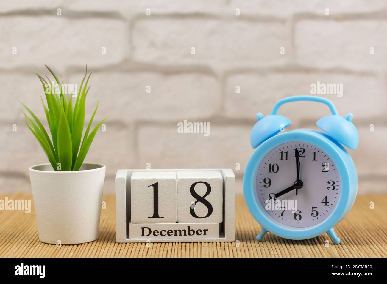calendar made of white wooden cubes and alarm clock on the table ...