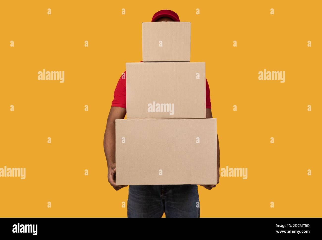 Black delivery man holding pile of boxes Stock Photo