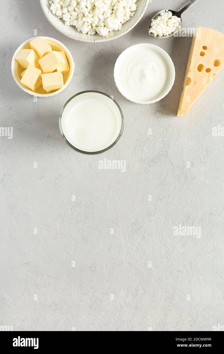 Natural, organic food most common dairy products are butter, cheese, milk, sour cream, cottage cheese flat lay on gray concrete background with copy s Stock Photo