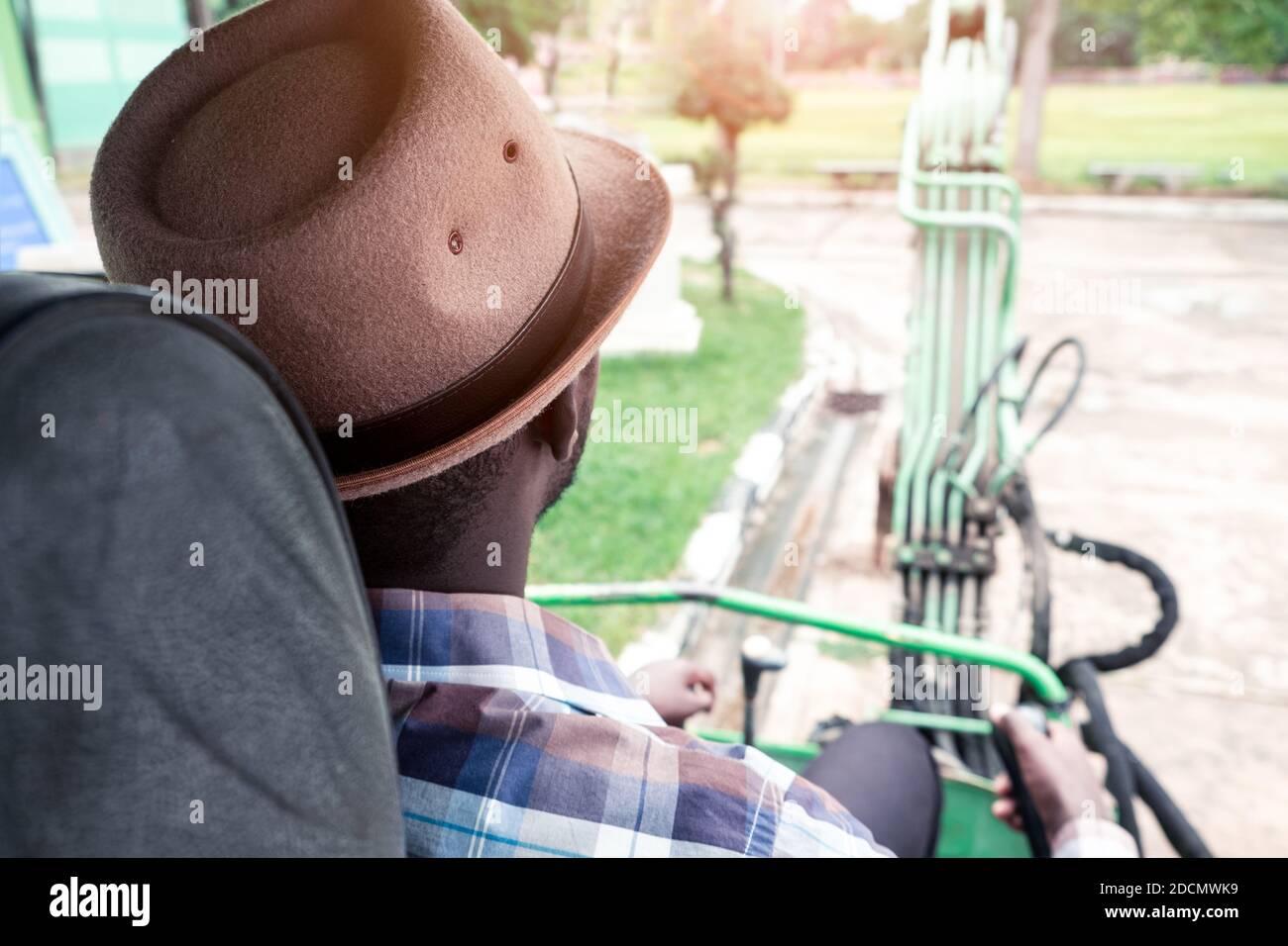 African worker driving heavy construction equipment backhoe Stock Photo