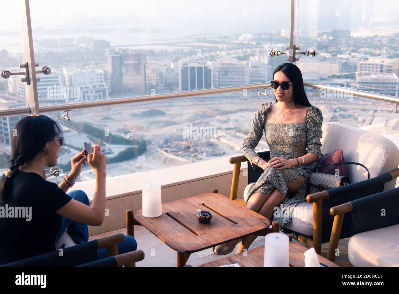 Woman girl friends taking photos in the high view coffee bar at sunset. Female friendship and fun time abstract Stock Photo