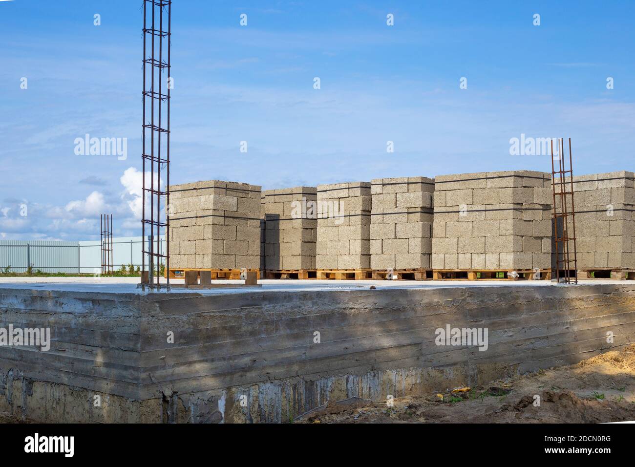 construction of a residential building, foundation and pallets of cinder blocks for walls. Stock Photo