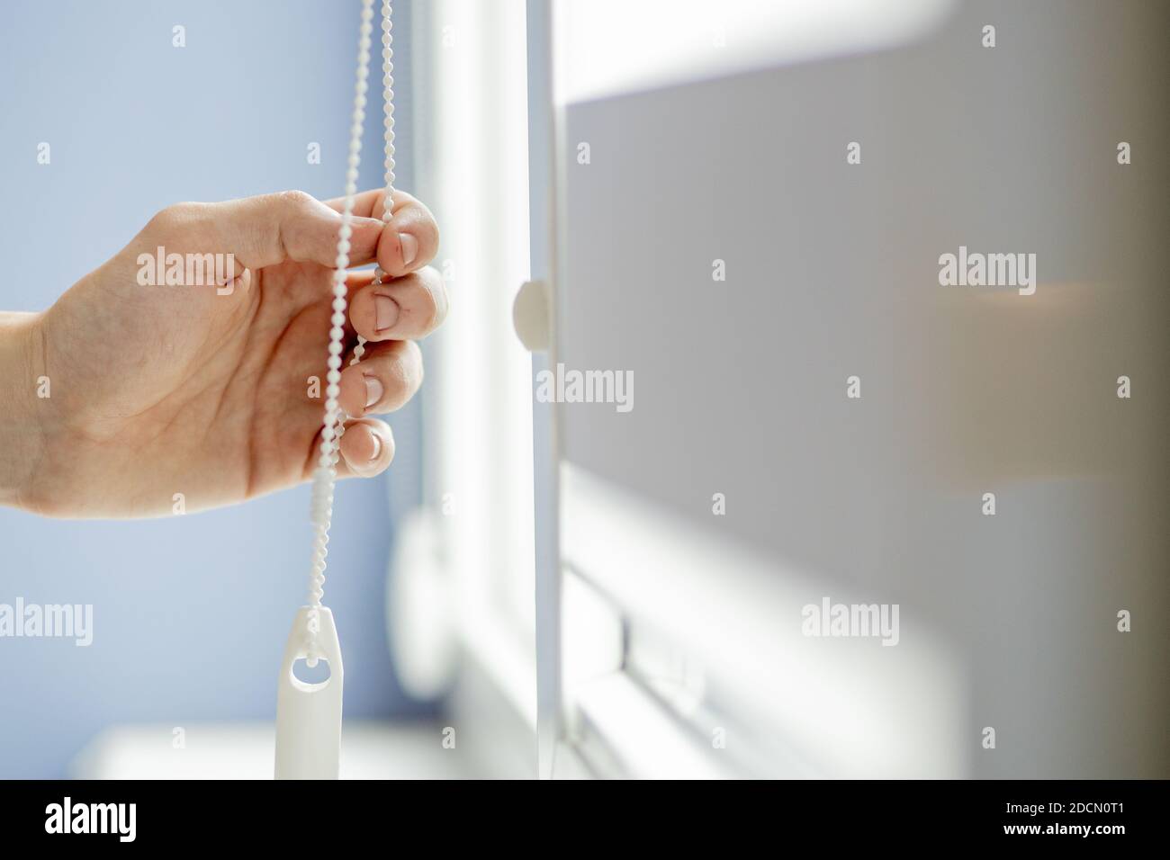Man testing cassette roller blinds on windows Stock Photo