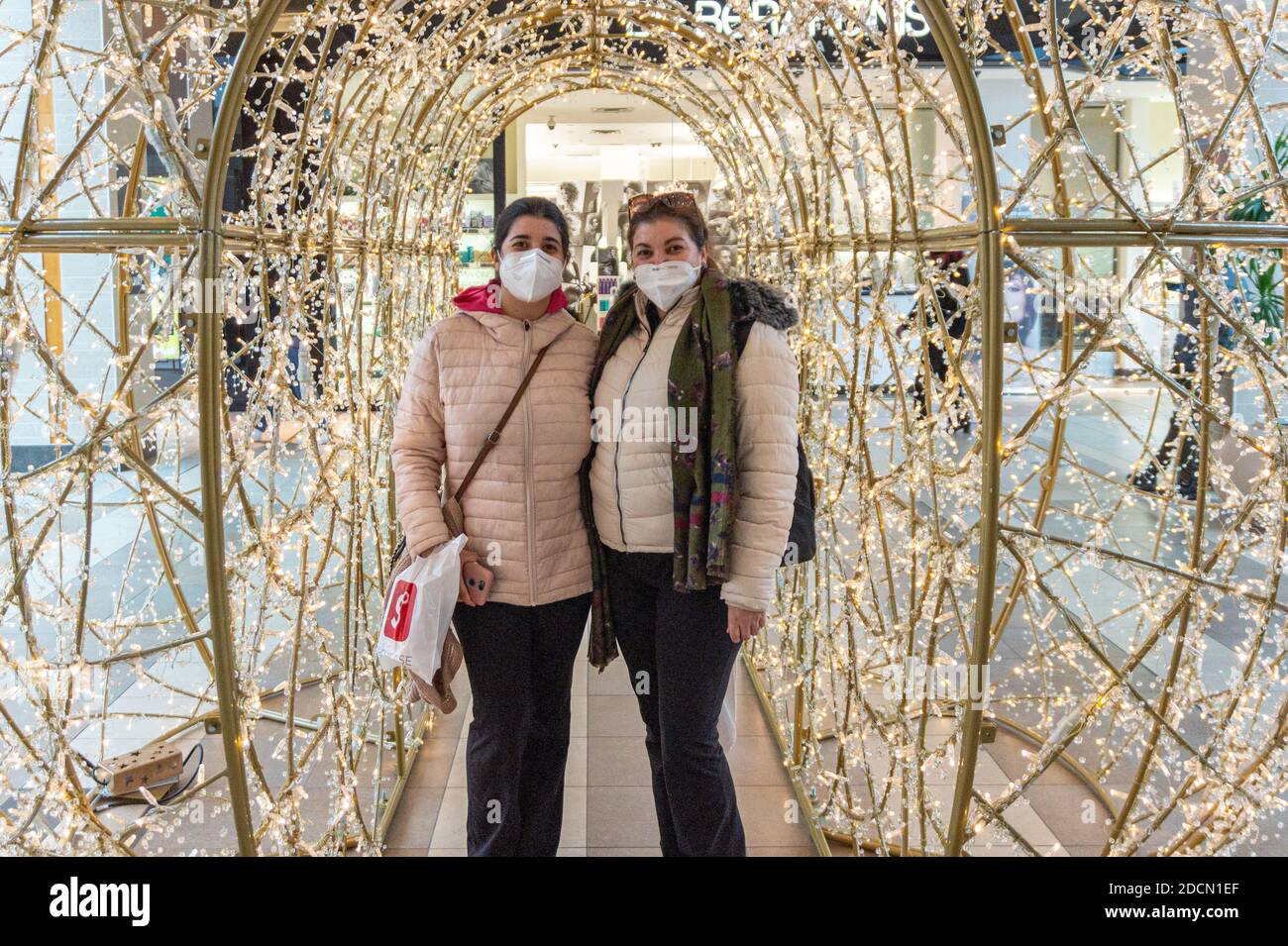 Portrait of mother and daughter in a mall Christmas lights during the Covid-19 pandemic Stock Photo