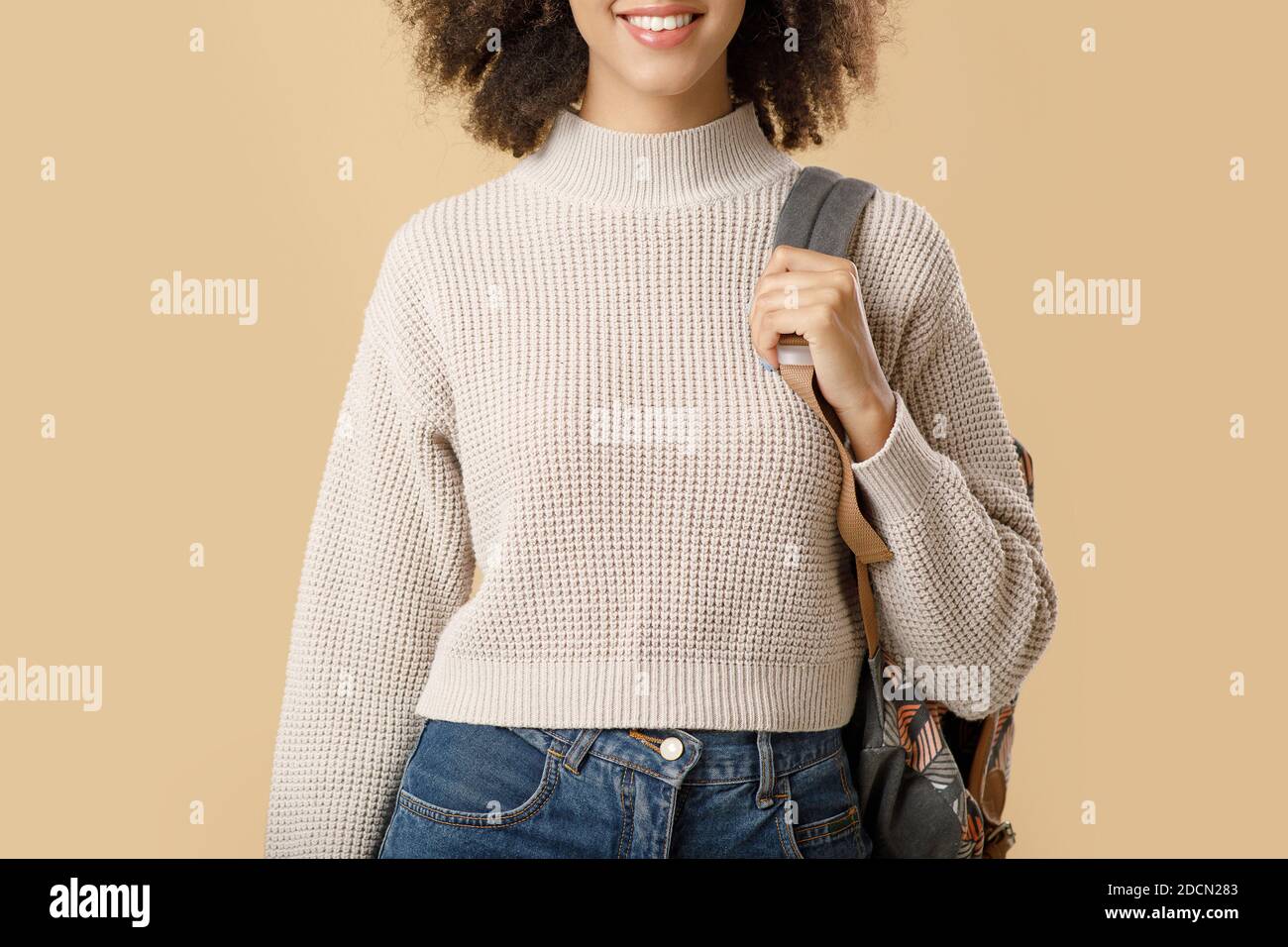 Cheerful millennial african american lady in sweater and glasses with backpack Stock Photo