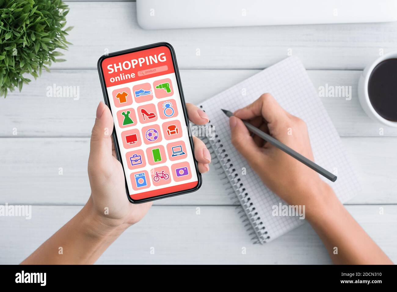 Woman Shopping Online On Mobile Phone And Taking Notes, Closeup Stock Photo