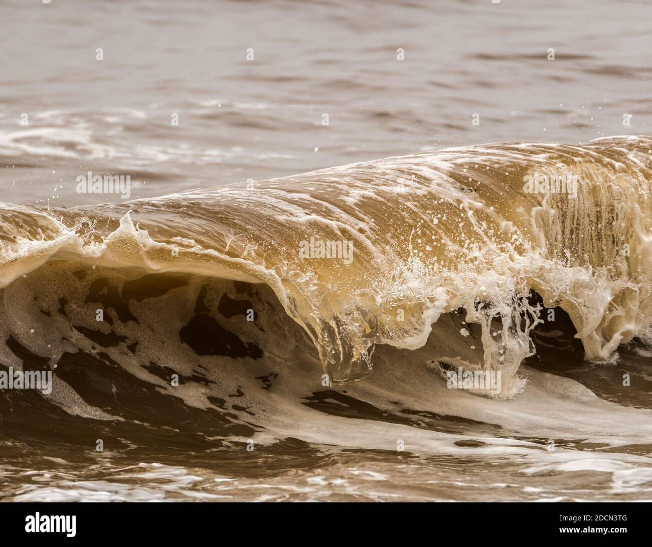 Photo of small breaking wave. The photo was taken with a fast shutter speed to freeze the action. There is lots of detail, and small bubbles. Stock Photo