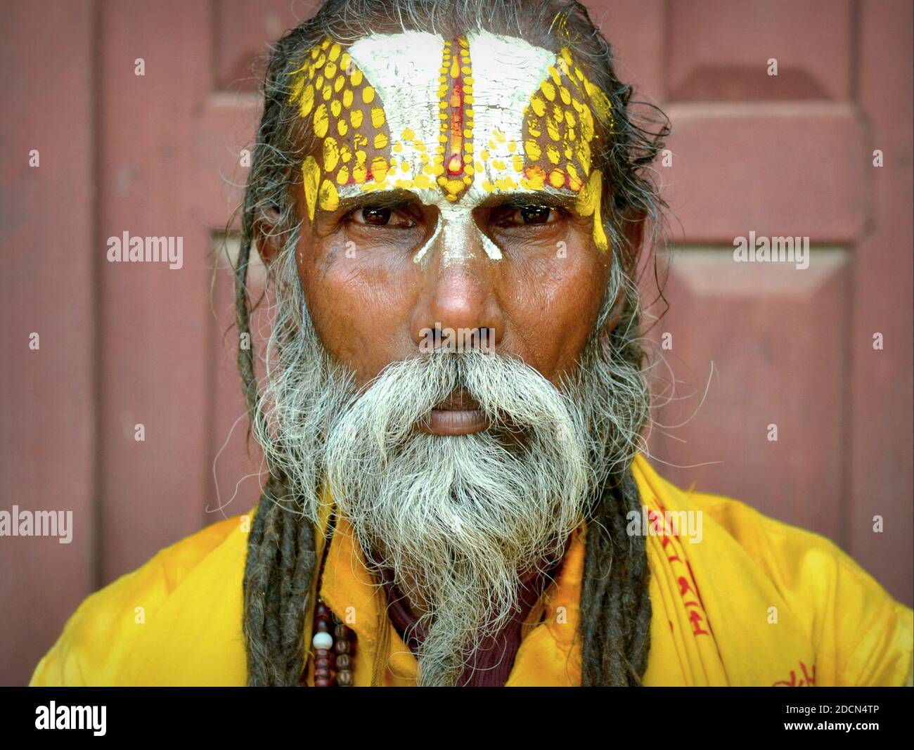Old Nepali Vaishnavite sadhu (Hindu holy man who worships Vishnu) with elaborately painted urdhva pundra mark on his forehead poses for camera. Stock Photo