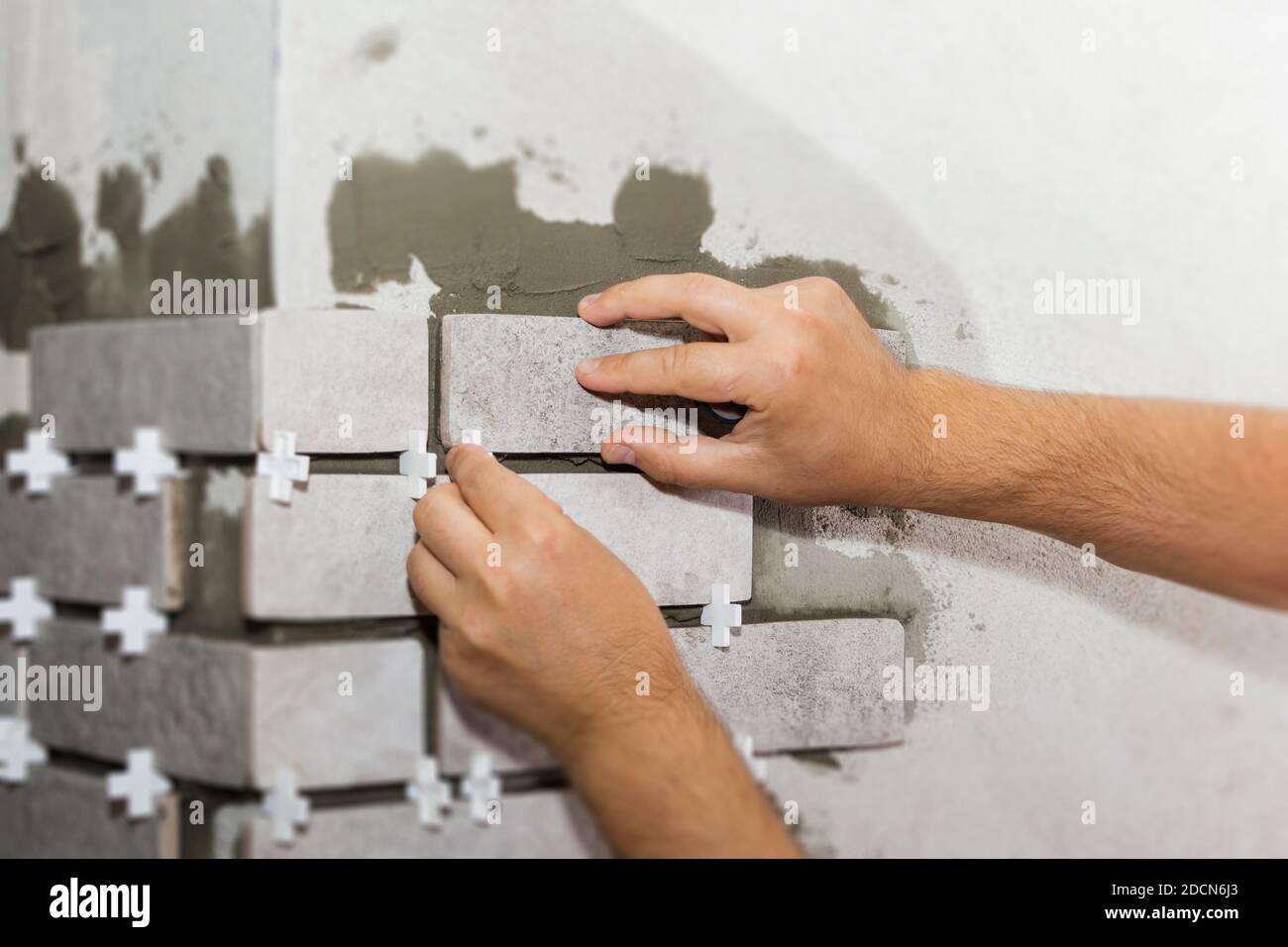 Laying Ceramic Tiles. The Builder makes repairs Stock Photo Alamy