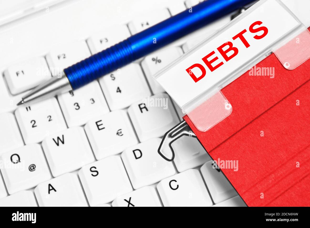 Debts red folder and white PC keyboard Stock Photo