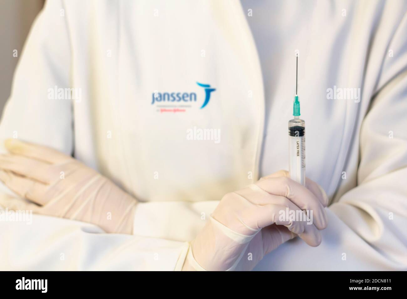 Lisbon, Portugal - November 22, 2020: Medic ,scientist, pharmacist holding Syringe with Janssen logo on lab coat. Coronavirus, Covid-19 vaccine concep Stock Photo