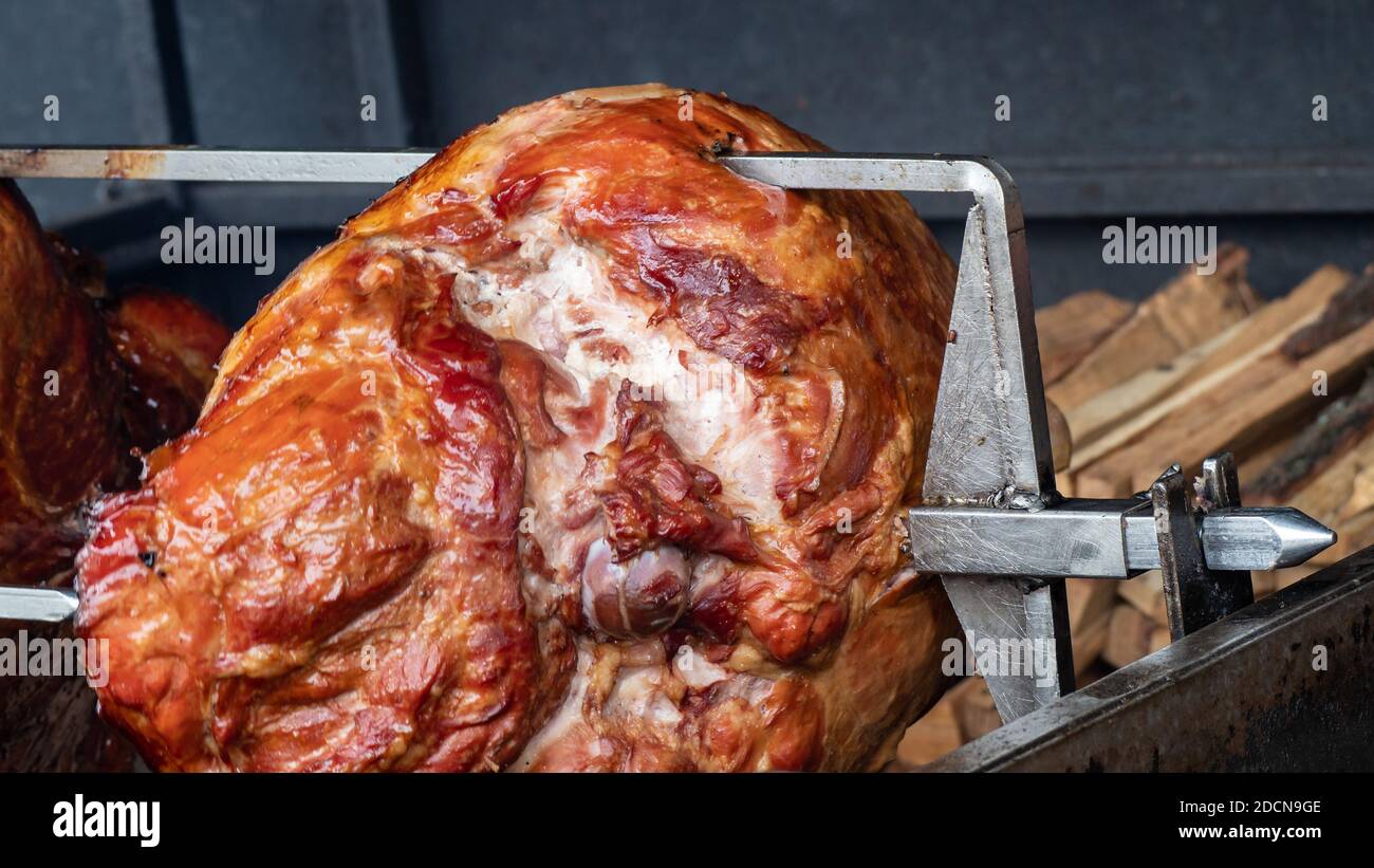 Traditional Veprevo knee (pork knuckle) being cooked on a spit roast in