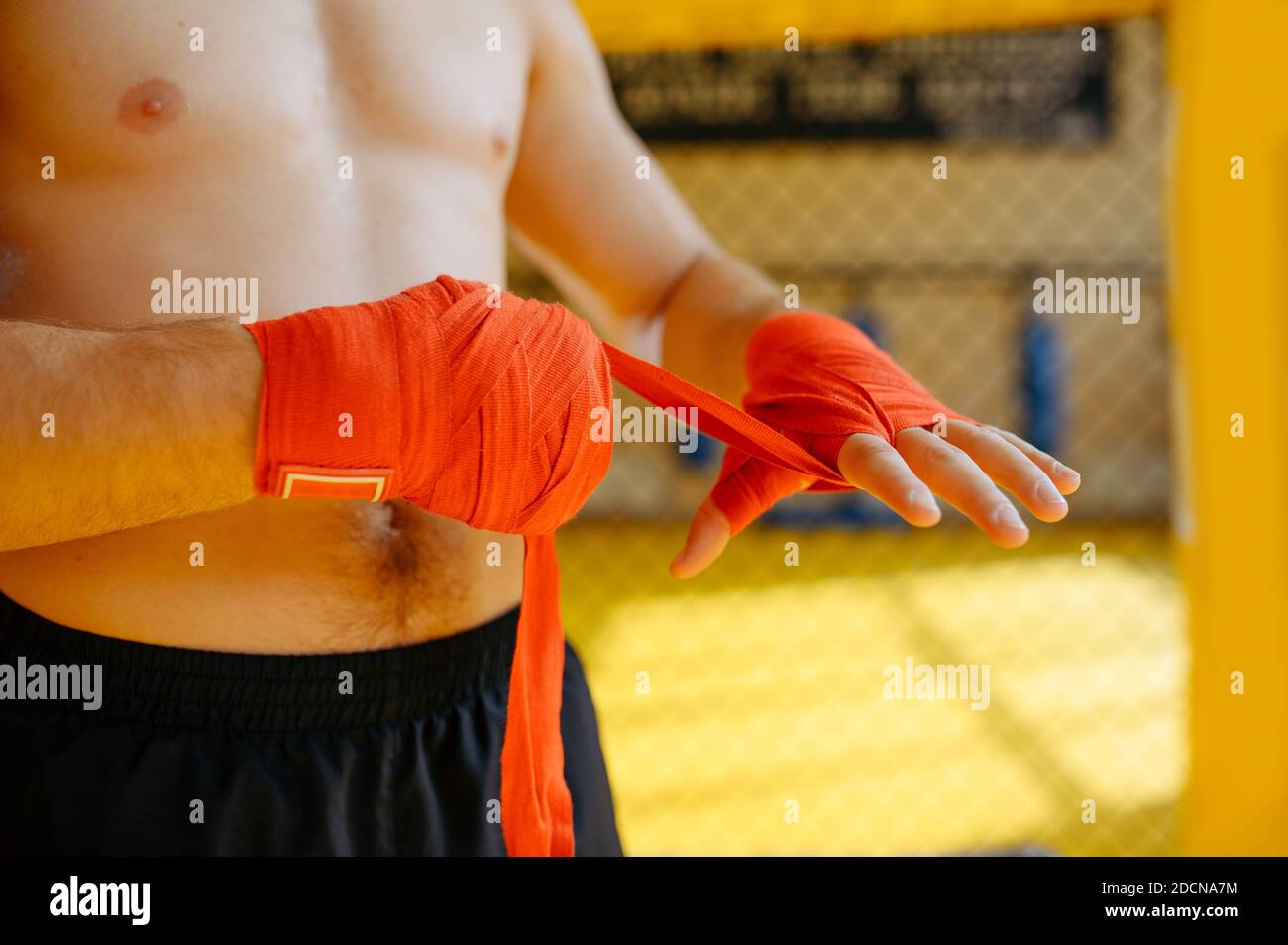 MMA fighter wraps bandages on his hands in gym Stock Photo