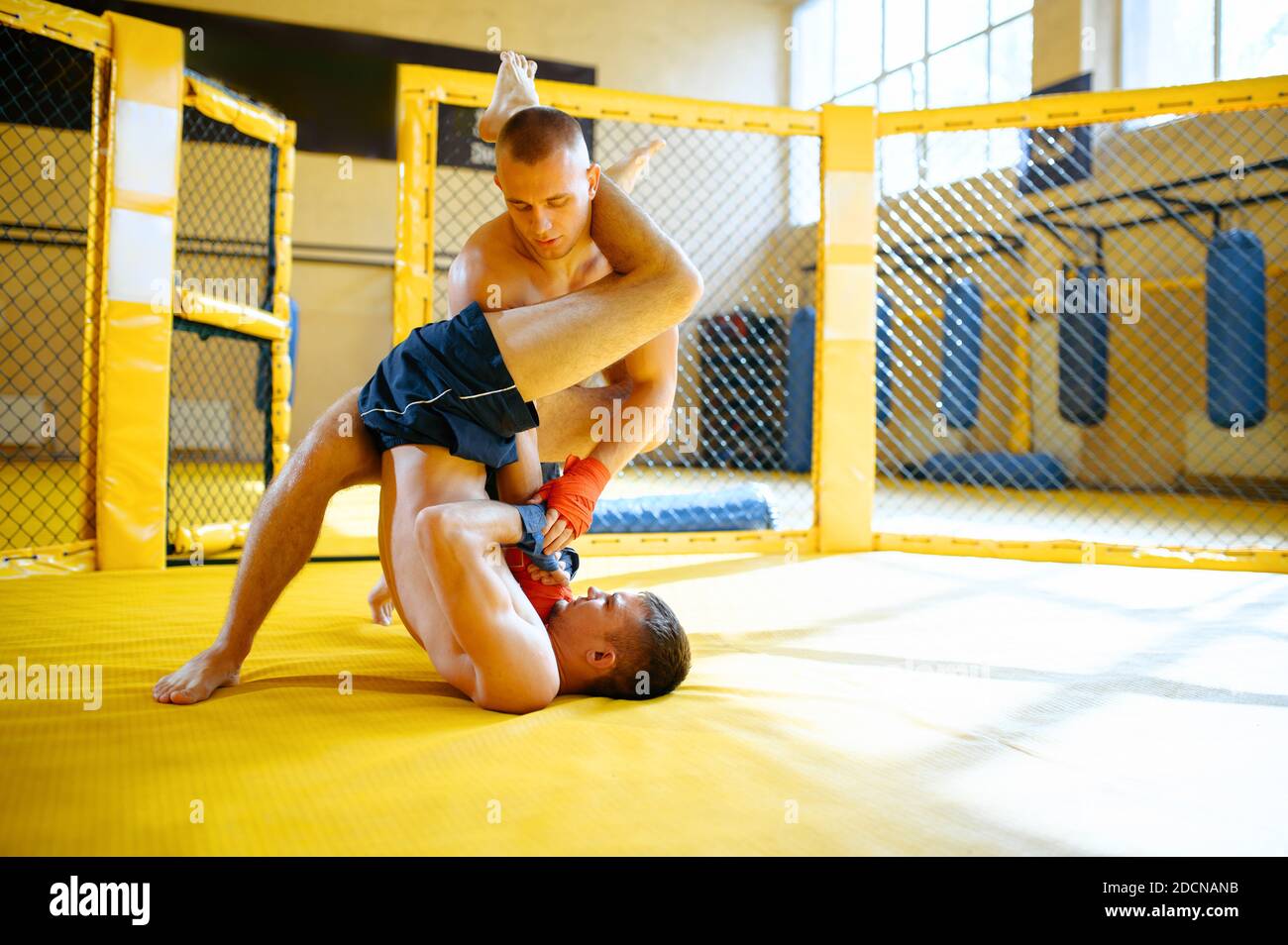 MMA fighter performs painful hold to his opponent Stock Photo