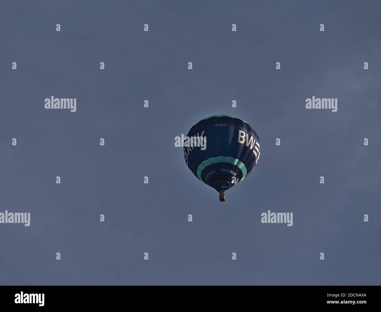 View of a blue and turquoise colored flying hot air balloon branded by public German bank Landesbank Baden-Württemberg (LBBW, BW Bank). Stock Photo