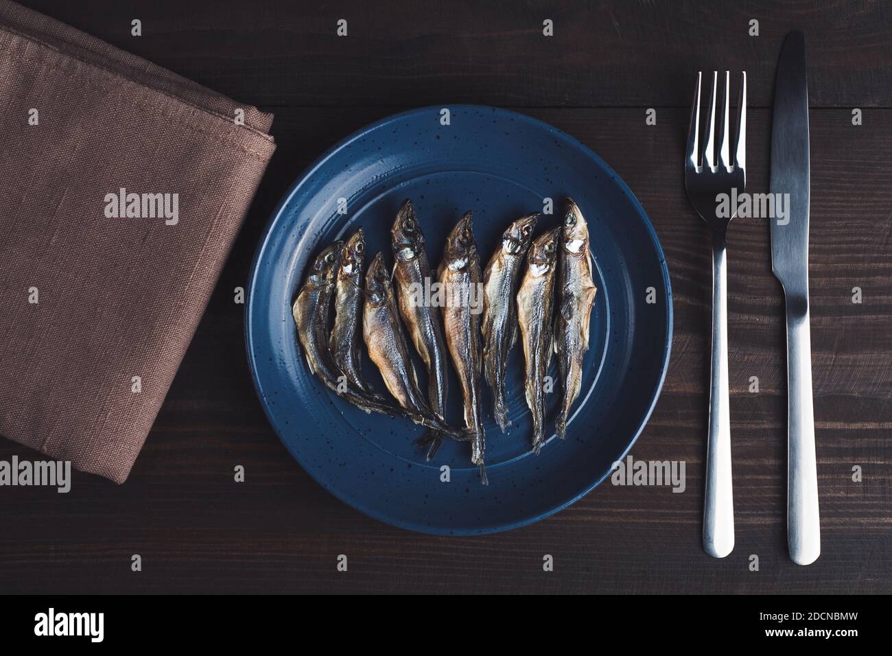 Salted dried fishes on plate. Stock Photo