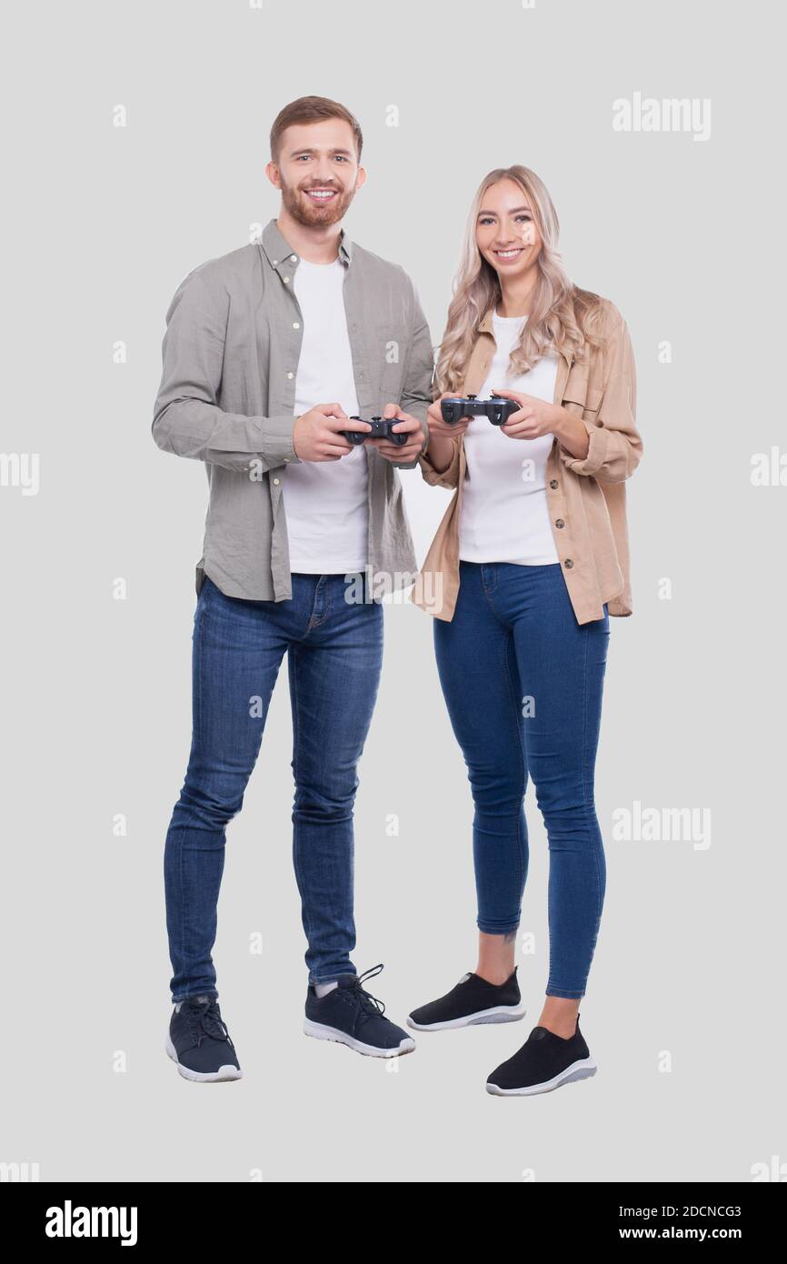 Couple Standing with Joysticks in Hands Smilling Isolated Stock Photo