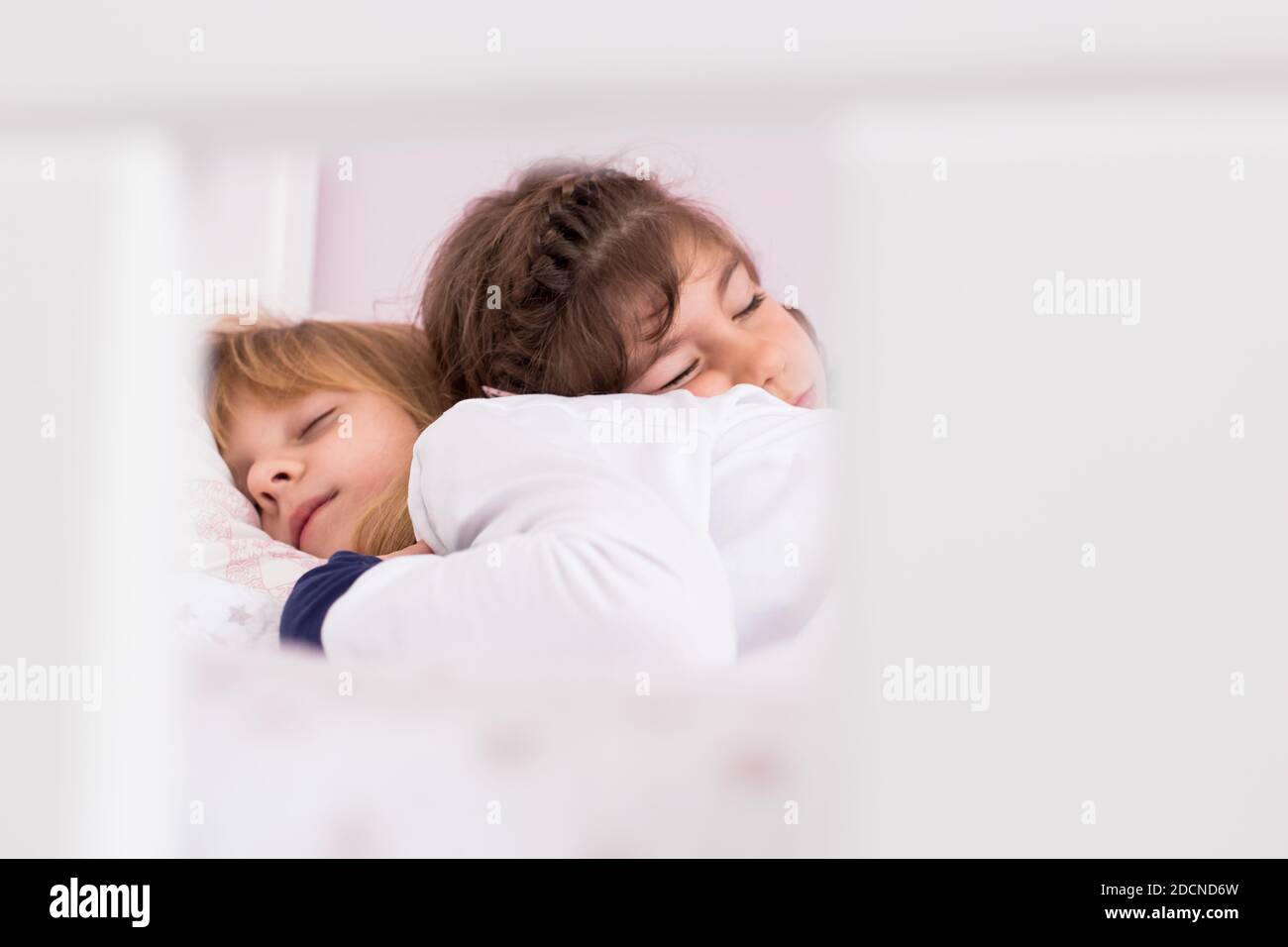 Two little girls, sister sleeping together, hugging. 