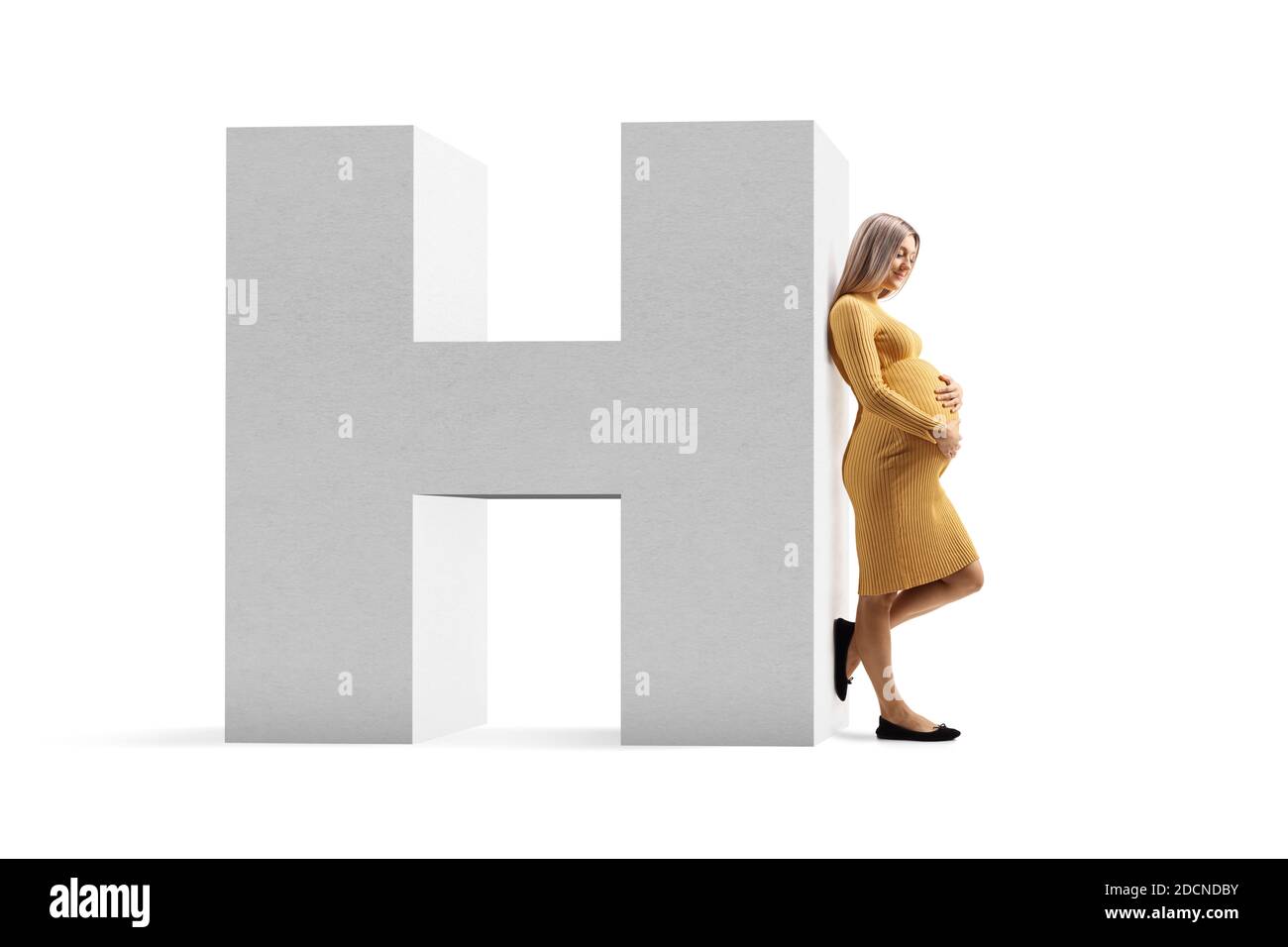 Full length profile shot of a pregnant woman in a yellow dress leaning on a hospital sign isolated on white background Stock Photo